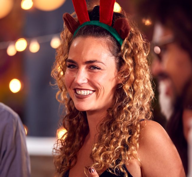 Multi-Cultural Group Of Friends Celebrating Dressing Up For Christmas Party In Bar